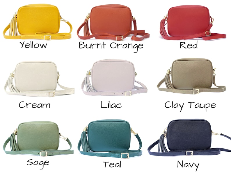 May include: Nine different coloured leather crossbody bags with a tassel. The bags are arranged in three rows of three. The colours are yellow, burnt orange, red, cream, lilac, clay taupe, sage, teal, and navy.