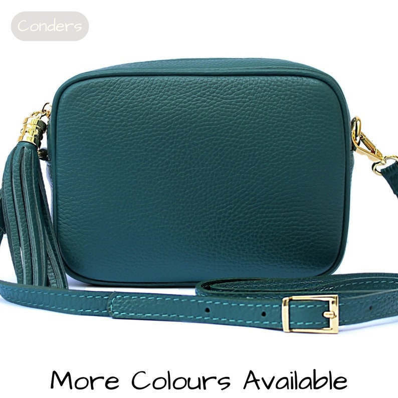 May include: A dark green leather crossbody bag with a gold tassel and adjustable strap. The bag has a rectangular shape and a textured leather finish.