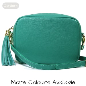 May include: A teal green leather crossbody bag with a gold chain and tassel. The bag has a flap closure and an adjustable strap.