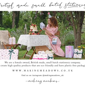 May include: An outdoor scene with a table set for a celebration, featuring gifts wrapped in patterned paper and tied with ribbons. The text "British made small batch stationery" is at the top. The scene includes a woman in a pink dress and a cake.