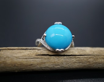 May include: A silver ring with a large turquoise gemstone and smaller diamonds set in the band.