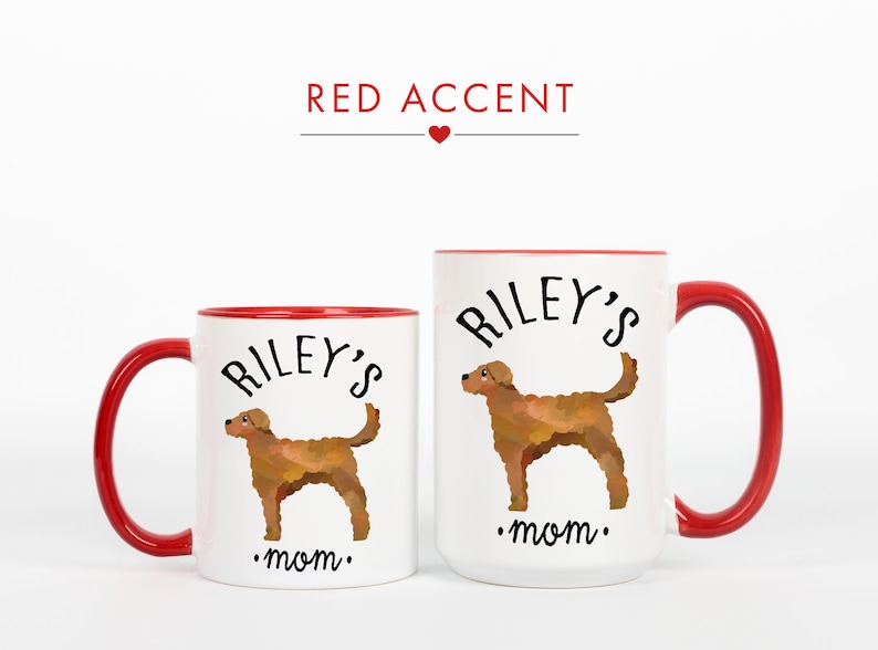 May include: Two white ceramic mugs with red accents. The mugs feature a brown dog illustration and the text "Riley's mom." The larger mug has a capacity of approximately 15 ounces, while the smaller mug is about 11 ounces.