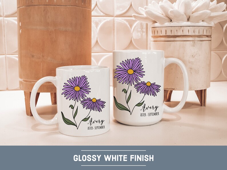 Puede incluir: Dos tazas de cer&aacute;mica blanca con un acabado brillante. Ambas tazas presentan un dise&ntilde;o de flores de aster p&uacute;rpura y el nombre "Avery" con el mes de nacimiento "septiembre".
