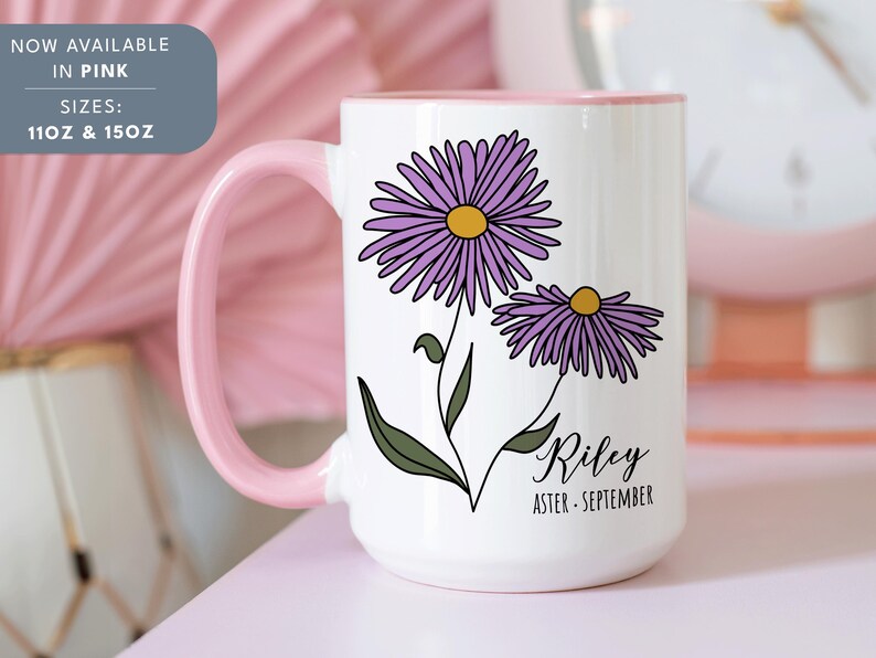 Puede incluir: Taza de cer&aacute;mica blanca con borde y asa de color rosa. La taza presenta una ilustraci&oacute;n de una flor de aster p&uacute;rpura con el nombre "Riley" y el texto "Aster - Septiembre".