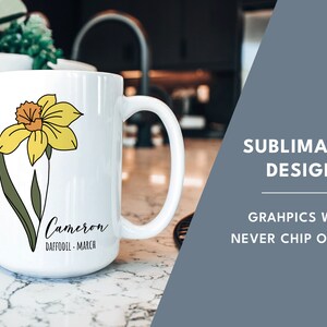 Peut inclure: Une tasse en c&eacute;ramique blanche avec un graphique de jonquille jaune et le texte "Cameron Daffodil - March". La tasse est sur un comptoir blanc. Le texte "Sublimated Design" et "Graphics will never chip or fade" sont en arri&egrave;re-plan.