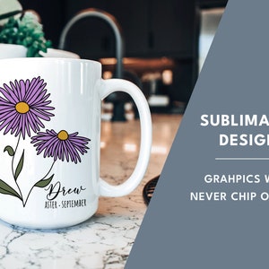 Puede incluir: Taza de cer&aacute;mica blanca con un dise&ntilde;o de flores moradas y el texto "Drew Aster - September". La taza est&aacute; sobre una encimera blanca.