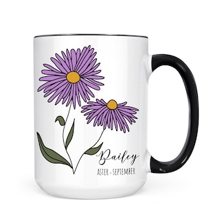 Puede incluir: Taza de cer&aacute;mica blanca con asa negra. La taza presenta una ilustraci&oacute;n de una flor de aster p&uacute;rpura con el nombre "Bailey" y el texto "Aster - Septiembre".