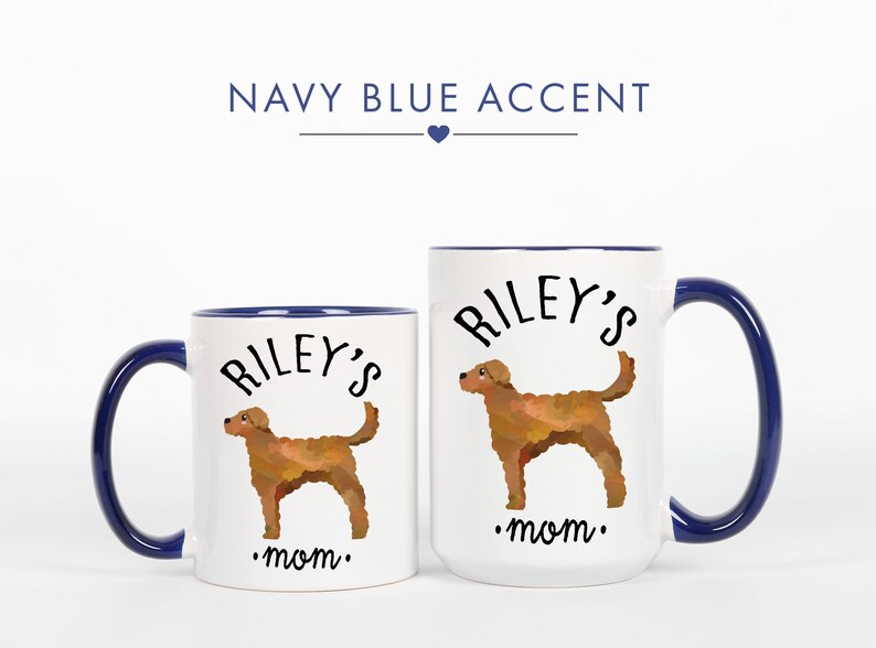 May include: Two white ceramic mugs with navy blue accents. Each mug features a brown dog illustration and the text "Riley's mom." The larger mug has a capacity of approximately 15 ounces.