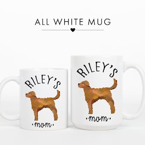 May include: Two white ceramic mugs with a brown dog illustration. The mugs have the text "Riley's mom" and "ALL WHITE MUG". The dog illustration is in a watercolor style.