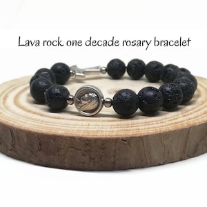 Könnte beinhalten: Eine weiße Keramik-Tasse mit schwarzem Henkel und dem Text "But First, Coffee" in schwarzer, handschriftlicher Schrift. Die Tasse steht auf einer weißen Oberfläche.