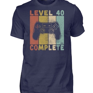 May include: A navy blue t-shirt with a vintage-style graphic of a video game controller and the text "Level 40 Complete".