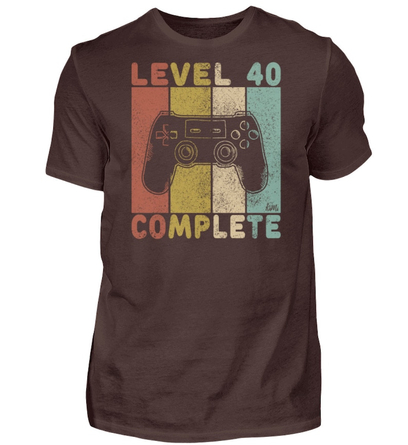 May include: A brown t-shirt with a retro-style graphic of a video game controller and the text "Level 40 Complete".