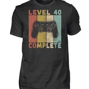 May include: A black t-shirt with a vintage-style graphic of a video game controller and the text "Level 40 Complete".