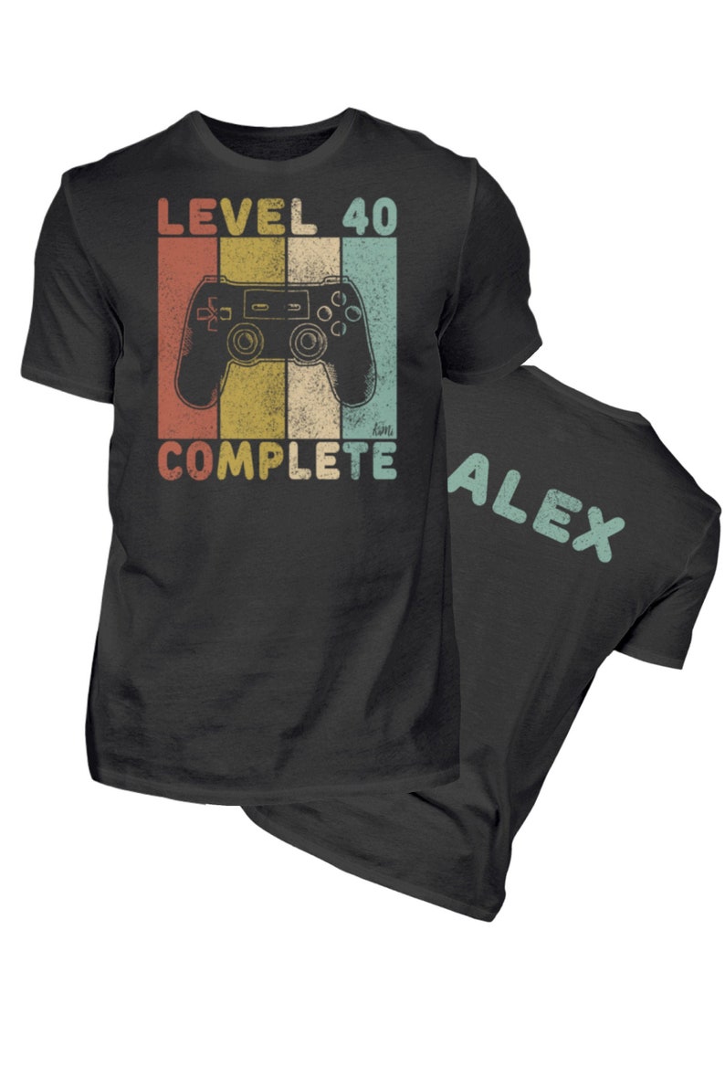 May include: Black t-shirt with a retro-style video game controller graphic and the text "LEVEL 40 COMPLETE". The back of the shirt has the name "ALEX" printed in a light blue color.