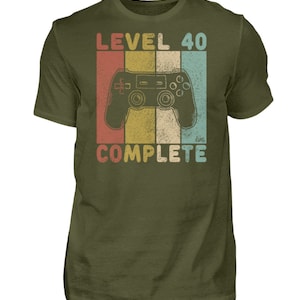 May include: A green t-shirt with a retro-style graphic of a video game controller and the text "Level 40 Complete".