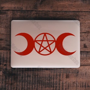 May include: A red triple moon and pentagram symbol sticker on a laptop. The symbol is a popular pagan and Wiccan symbol.