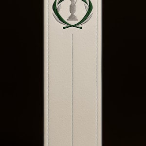 May include: A rectangular off-white leather bookmark featuring a vertical stitched line down the center and a top-centered embroidered emblem. The emblem displays a grey trophy silhouette encircled by two overlapping green laurel leaf branches.