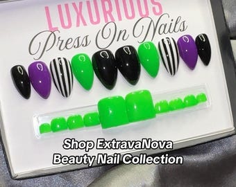 May include: A set of press-on nails in a box labeled LUXURIOUS Press On Nails and Shop ExtravaNova Beauty Nail Collection. The set includes almond-shaped nails in black, purple, lime green, and black-and-white stripes, plus bright green toe nails.