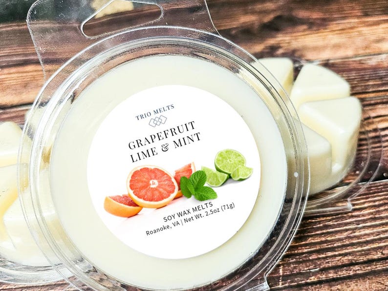 Puede incluir: Un recipiente de pl&aacute;stico transparente contiene un derrite de cera de soja con la etiqueta "Grapefruit Lime & Mint". La etiqueta presenta im&aacute;genes de rodajas de pomelo, gajos de lima y hojas de menta. Peso neto 71g.