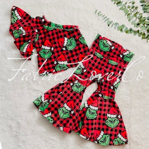 May include: Red and black plaid bell bottom pants and a matching one-shoulder top with a Grinch print.