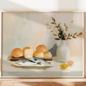 May include: A framed still life painting featuring a wooden cutting board with rolls, a plate with fish, a white vase with greenery, and a lemon. The color palette includes beige, yellow, and white.