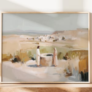 May include: An art print depicting a biblical scene with two figures at a well. The landscape features a muted color palette of beige, brown, and green, with a distant village and a light gray sky. The artwork is framed in a light wood.