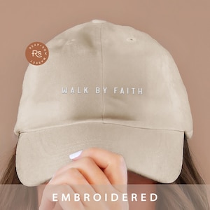 Op de afbeelding: Beige baseballpet met de tekst "WALK BY FAITH" in wit geborduurd op de voorkant.