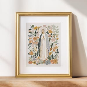 May include: A framed art print featuring a watercolor illustration of a religious figure surrounded by colorful flowers. The artwork is set in a gold frame and displayed on a wooden surface, creating a serene and decorative piece.