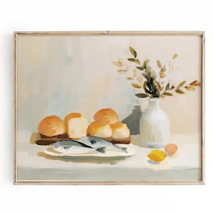 May include: A framed still life painting featuring a rustic arrangement. It depicts a wooden board with rolls and a plate with fish. A white vase holds greenery, and a lemon and egg are also present. The color palette is soft and warm.