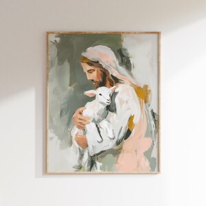 Peut inclure: Une impression d'art d'une peinture repr&eacute;sentant une figure aux longs cheveux bruns et une robe blanche tenant un agneau blanc. La peinture a un style doux au pinceau avec des couleurs sourdes, dont le rose, le vert et l'or, et est encadr&eacute;e en bois clair.