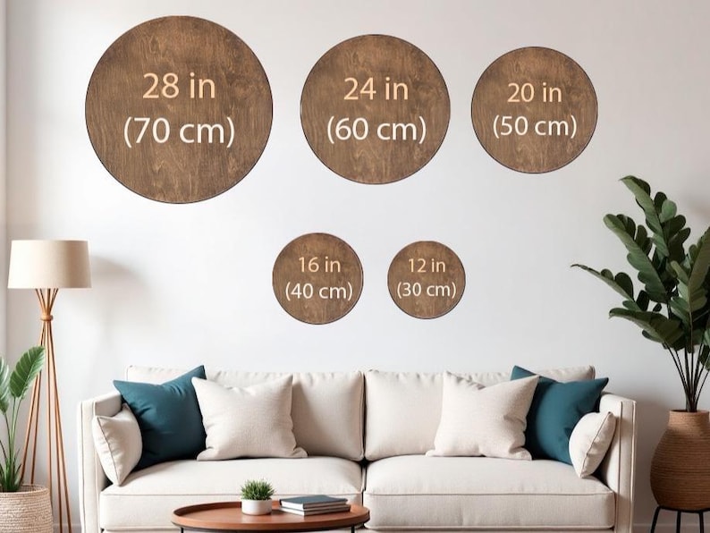 May include: A display of five wooden, circular wall art pieces in varying sizes: 28 in (70 cm), 24 in (60 cm), 20 in (50 cm), 16 in (40 cm), and 12 in (30 cm). The brown circles are mounted on a white wall above a sofa with pillows.