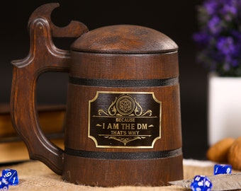 May include: A dark brown wooden beer stein with a handle and a lid. The stein has a gold-colored plaque with the text "I AM THE DM THAT'S WHY". The stein is surrounded by blue dice.