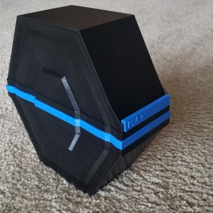 以下が含まれることがあります： 側面に青いストライプと「1023」の文字が書かれた黒い六角形の箱