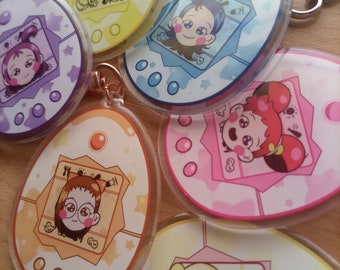 May include: Five colorful plastic keychains shaped like Tamagotchi virtual pets. Each keychain features a different character with a unique design and color scheme. The keychains are perfect for fans of the classic Tamagotchi.