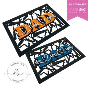 May include: Two laser cut wood signs with a black frame and a design of tools. The top sign says "Dad I love you" in orange and white letters. The bottom sign says "We love you Dad" in blue and white letters.
