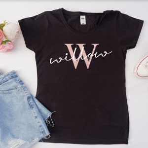 May include: Black t-shirt with a pink "W" and the word "willow" written in white script.