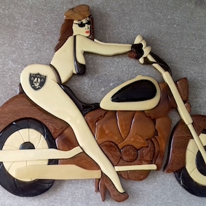 placa de parede de uma garota motociclista em uma motocicleta, madeira envernizada