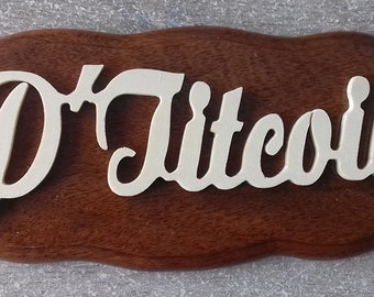 May include: A wooden sign with a wavy edge, featuring the text "D'Litecoin" in white cursive lettering.