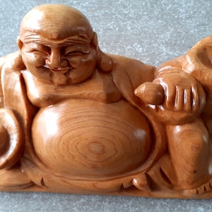 estatueta de Buda sentado rindo em madeira envernizada