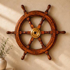 May include: A circular wooden ship wheel featuring a rich brown finish with visible wood grain patterns. The wheel has eight spokes radiating from a central, polished brass hub. The design includes a circular outer rim and a smaller inner ring.