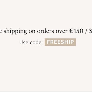 May include: Text on a light beige background reads "Free shipping on orders over $165". Below, it says "Use code: FREESHIP" in a rectangular box. The text is in a simple, clean font.