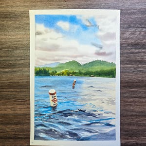 May include: Watercolor painting of a lake scene with a blue sky and fluffy clouds. Two red and white buoys mark a swim area. Green hills and trees line the distant shore. The water has gentle waves.