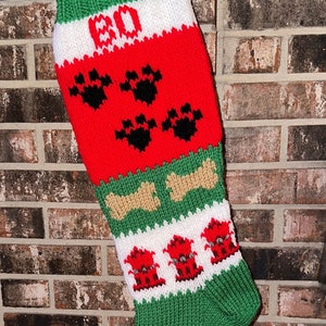 May include: A red, white, and green knitted Christmas stocking with a white 'BO' in the top section, followed by black paw prints, tan bone-shaped designs, and red fire hydrants.