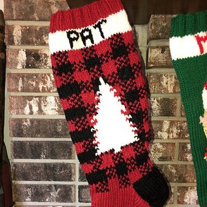 Può includere: Calza di Natale rossa e nera a quadri con un albero bianco e il nome "PAT" ricamato sul polsino.