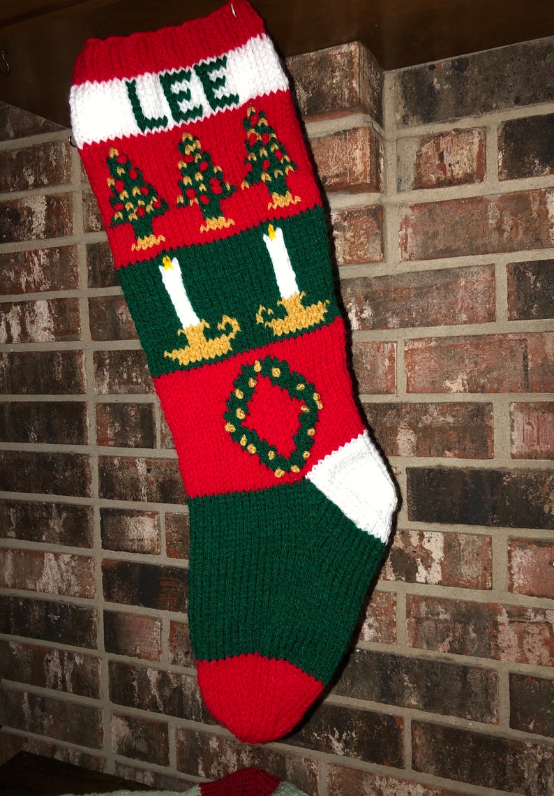 May include: Red, green and white knitted Christmas stocking with the name "LEE" and a wreath design.