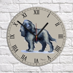 May include: A round wall clock with Roman numeral markings and a black and red clock hand. The clock face features a watercolor painting of a black dog.