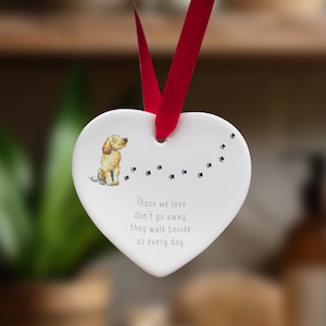 Può includere: Ciondolo a forma di cuore in ceramica bianca con una piccola illustrazione di un cane e il testo "Those we love don't go away, they walk beside us every day".