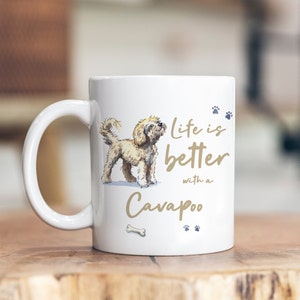 Può includere: Tazza in ceramica bianca con un'illustrazione marrone di un cane Cavapoo e il testo "Life is better with a Cavapoo".