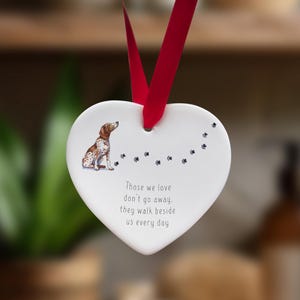 Peut inclure: Ornement en forme de cœur en céramique blanche avec une illustration de chien brun et blanc et le texte "Those we love don't go away, they walk beside us every day".