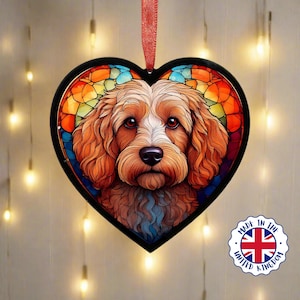 Può includere: Un ornamento a forma di cuore in vetro colorato con un'illustrazione colorata di un cane marrone e bianco con il naso nero. L'ornamento è realizzato nel Regno Unito.